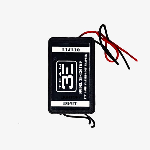 A black 12 volt waterproof power supply with red and black wires and a label that includes the text '12V', 'INPUT', and 'TEAM 3'.