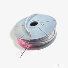 Spool of wire with pink and red color on a white background
