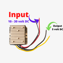 A silver DC to DC 5 volt converter with red and blue arrows indicating the input and output connections, and a yellow wire with a connector for grounding.