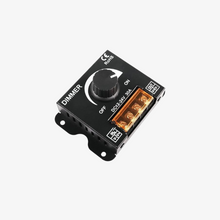 A black DIMMER DC 12-24V 30A electrical switch with a on/off switch and yellow terminal connectors.
